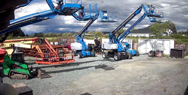 Boom lifts and a skid steer in the rental yard